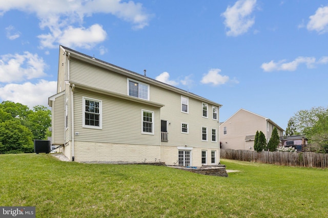back of house with fence, a yard, brick siding, and cooling unit