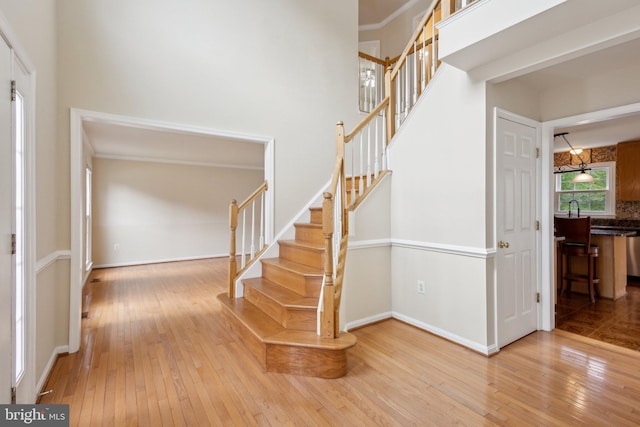 stairs with baseboards, a high ceiling, and hardwood / wood-style flooring