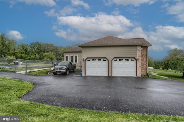 2038 E Harrisburg Pike, Middletown, PA 17057 - view of property exterior featuring stone siding, a garage, fence, aphalt driveway, and a shingled roof