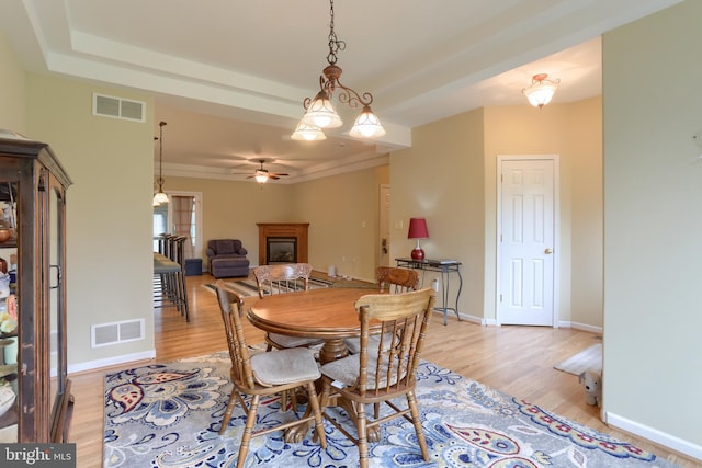 2038 E Harrisburg Pike, Middletown, PA 17057 - dining area with light wood-type flooring, a fireplace, visible vents, and a ceiling fan