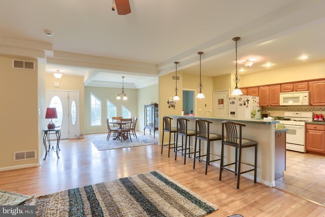 2038 E Harrisburg Pike, Middletown, PA 17057 - kitchen featuring light wood-type flooring, white appliances, visible vents, and a kitchen bar