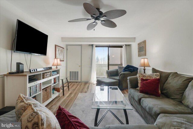 living area with ceiling fan, visible vents, and wood finished floors