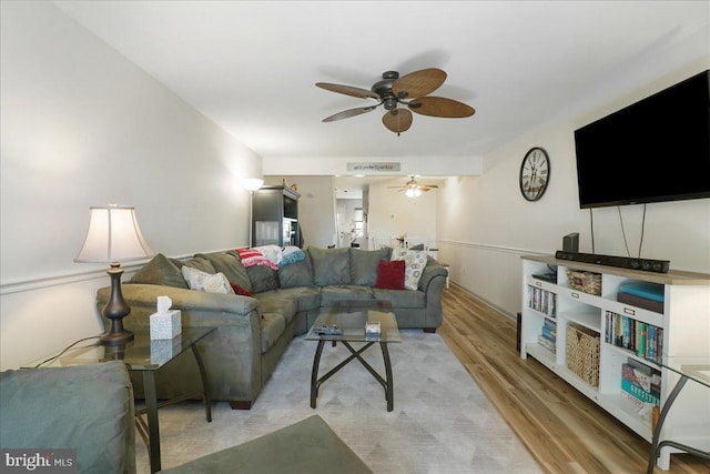 living room featuring a ceiling fan and wood finished floors