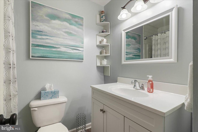 bathroom with vanity, toilet, and curtained shower