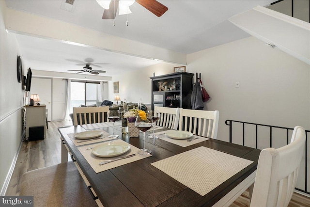 dining space with visible vents, a ceiling fan, and wood finished floors