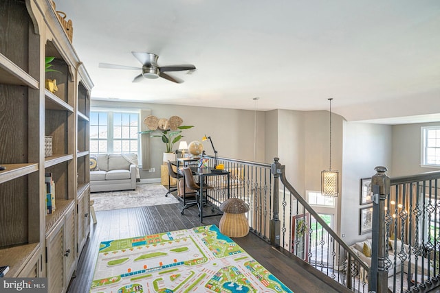interior space featuring baseboards, ceiling fan, and wood-type flooring