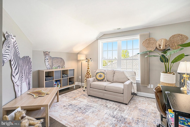 living area featuring baseboards, visible vents, wood finished floors, and lofted ceiling