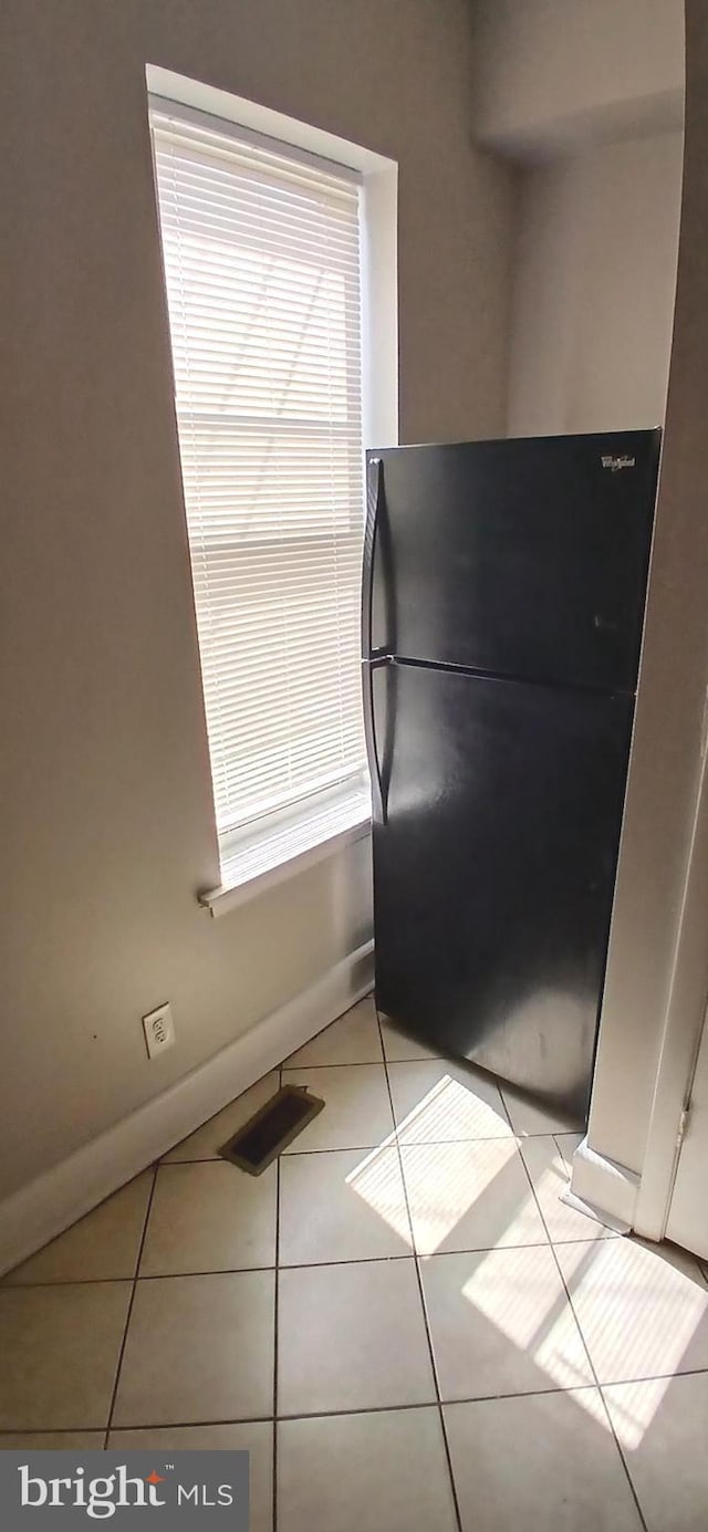 interior details featuring freestanding refrigerator, baseboards, and visible vents