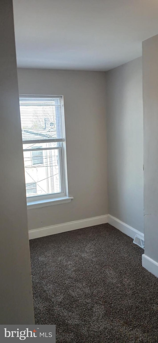 carpeted empty room with baseboards and visible vents