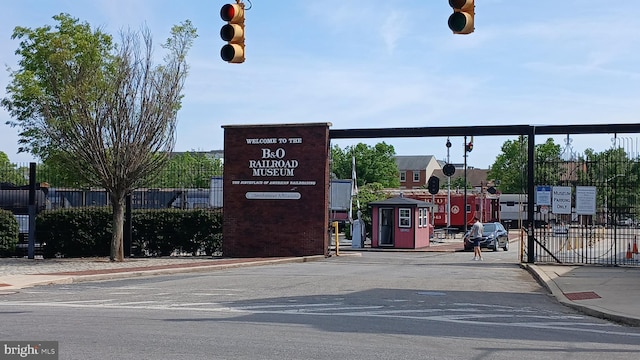 view of road with traffic signs, sidewalks, traffic lights, and curbs