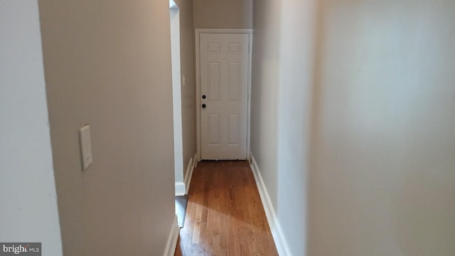 hall with baseboards and wood finished floors