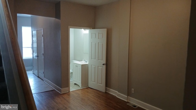 unfurnished bedroom featuring baseboards, wood finished floors, and visible vents