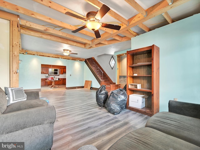 living area with ceiling fan, baseboards, stairway, and light wood-type flooring