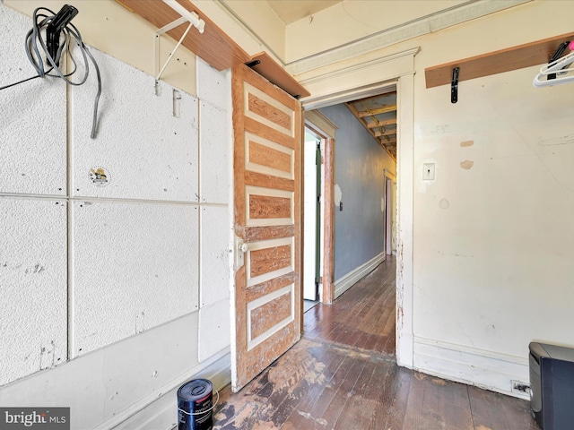 corridor with baseboards and hardwood / wood-style floors