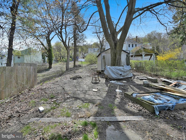 view of yard featuring fence, an outbuilding, and a shed