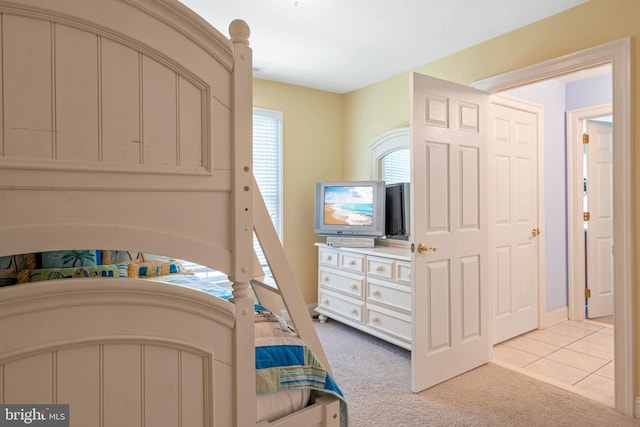 bedroom with baseboards and light carpet