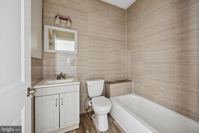 bathroom featuring a bathing tub, toilet, tile walls, and vanity