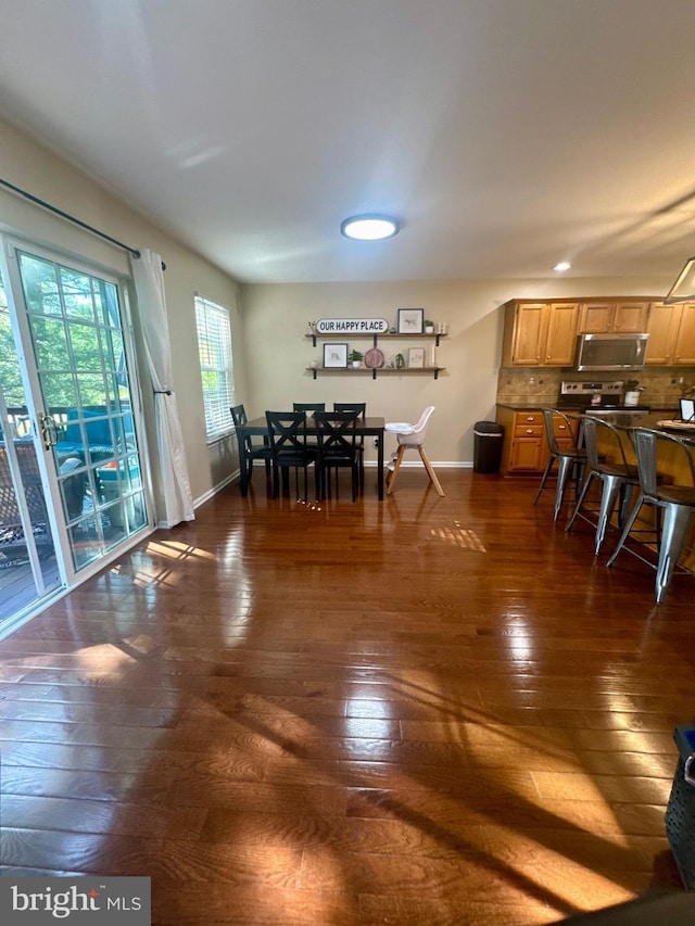 dining space with recessed lighting, baseboards, and dark wood-style floors
