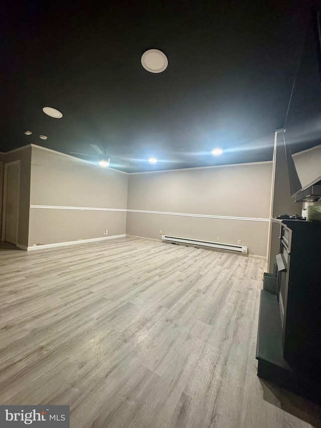 below grade area with recessed lighting, baseboards, a baseboard heating unit, and light wood-style flooring
