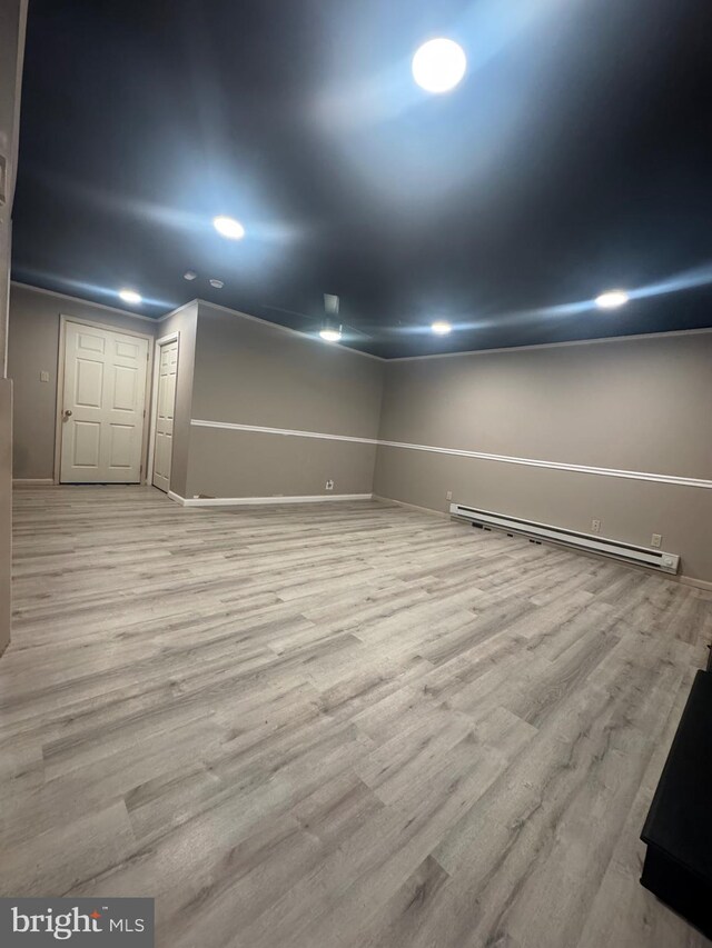 interior space featuring recessed lighting, baseboards, wood finished floors, and a baseboard radiator