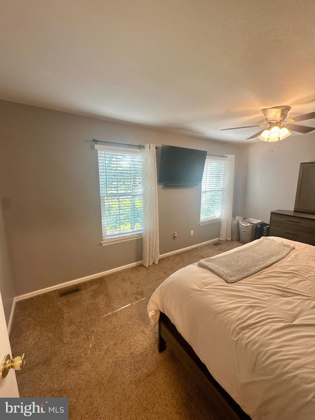 carpeted bedroom with baseboards, ceiling fan, and visible vents