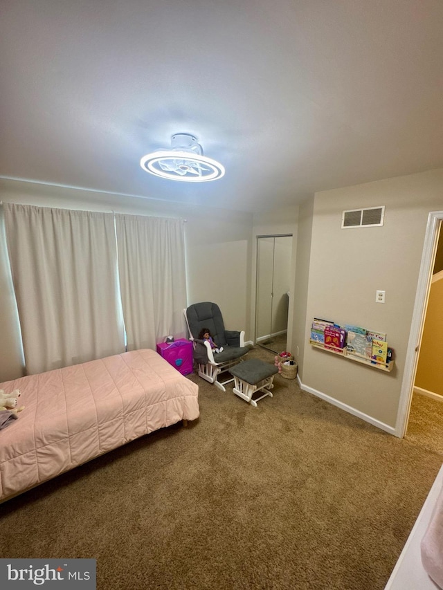 bedroom featuring baseboards, visible vents, carpet, and a closet