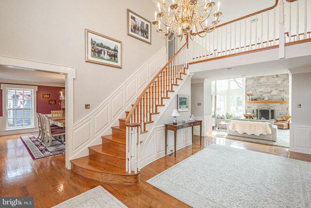 stairway with a high ceiling, wood finished floors, and a decorative wall
