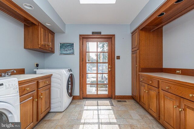 clothes washing area featuring cabinet space, hookup for an electric dryer, baseboards, and stone finish floor