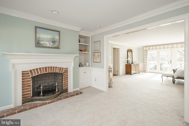 living room with a brick fireplace, ornamental molding, built in shelves, and carpet