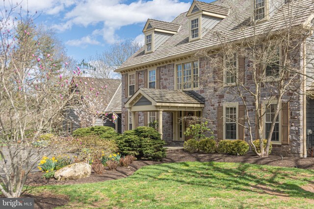 colonial house with a front yard and stone siding