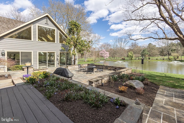 wooden deck with a patio and a water view