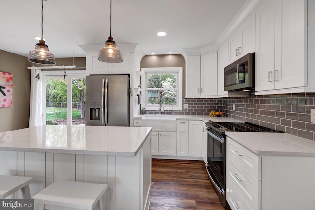 kitchen featuring decorative backsplash, appliances with stainless steel finishes, a sink, white cabinets, and dark wood-type flooring