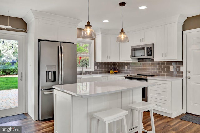kitchen with dark wood-style flooring, stainless steel appliances, and white cabinetry