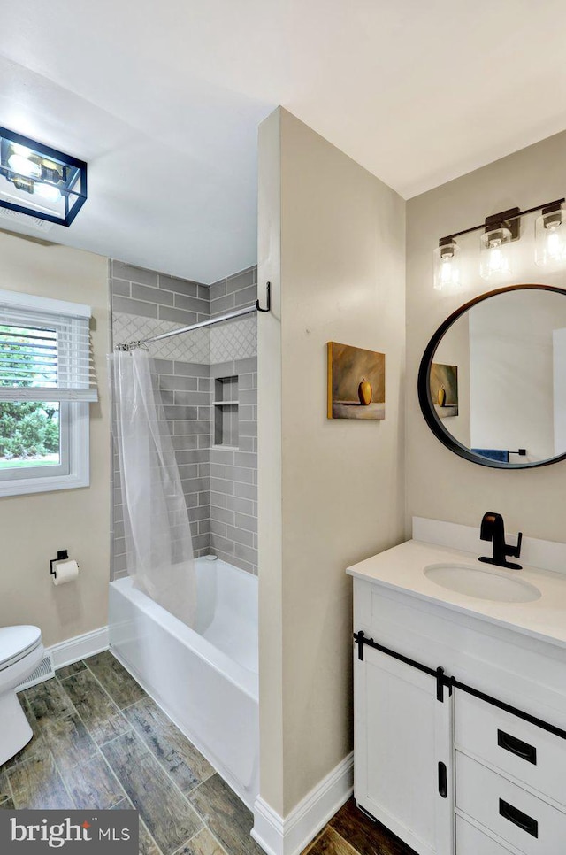 full bath featuring toilet, baseboards, shower / bath combo, and vanity