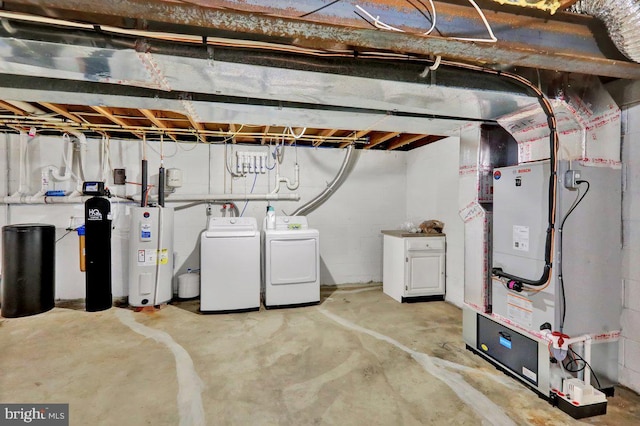unfinished below grade area featuring separate washer and dryer, heating unit, and electric water heater