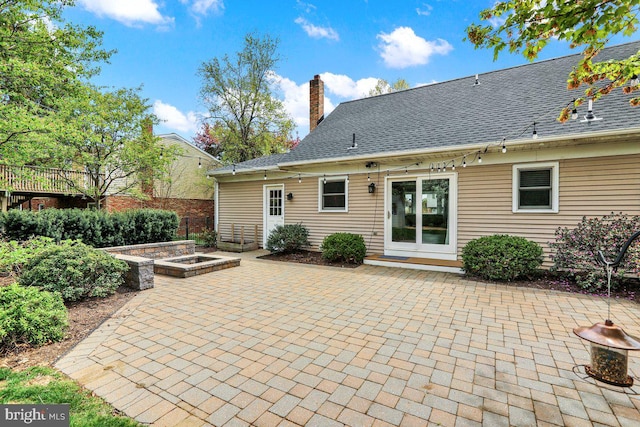 rear view of property featuring fence, a chimney, and a patio area