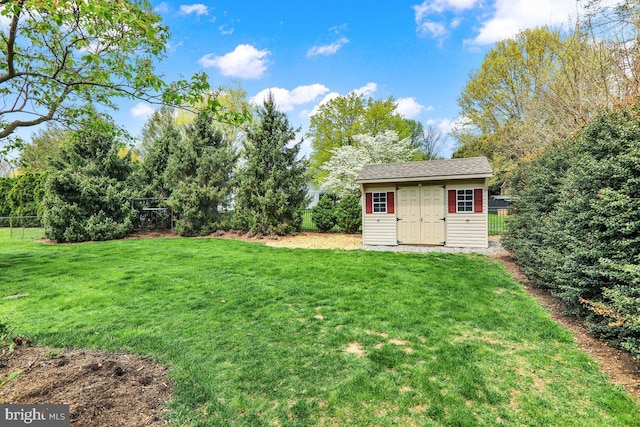 view of yard featuring a storage shed, fence, and an outbuilding