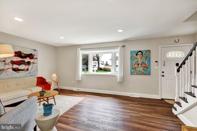 living area featuring stairway, baseboards, dark wood finished floors, and a wealth of natural light