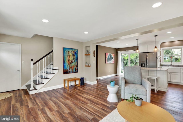 living room featuring stairs, recessed lighting, baseboards, and dark wood finished floors