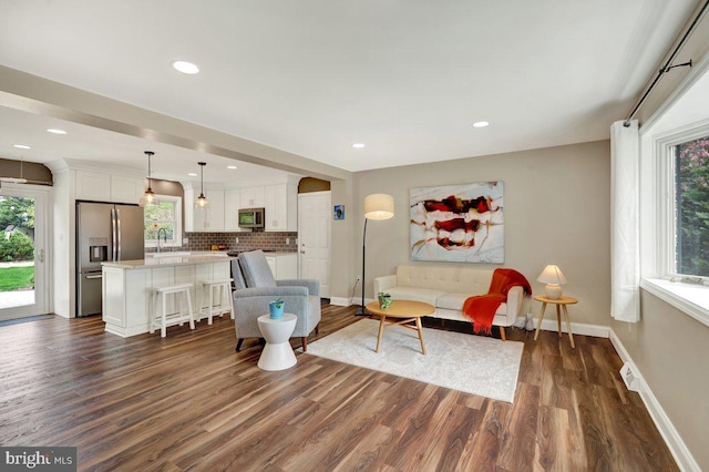 living area with recessed lighting, baseboards, and dark wood finished floors