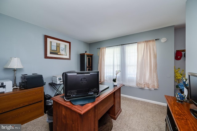 home office with baseboards and light carpet