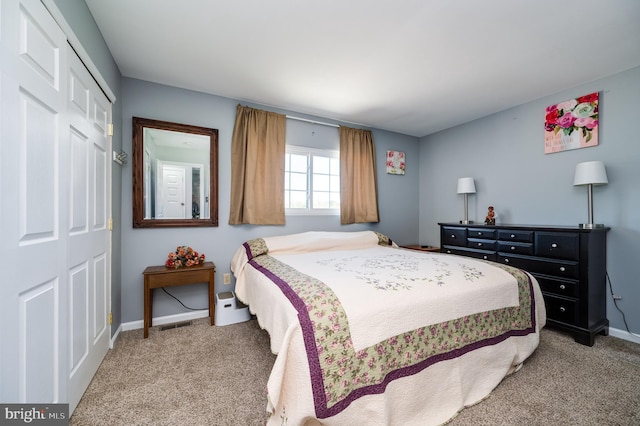 carpeted bedroom with a closet and baseboards