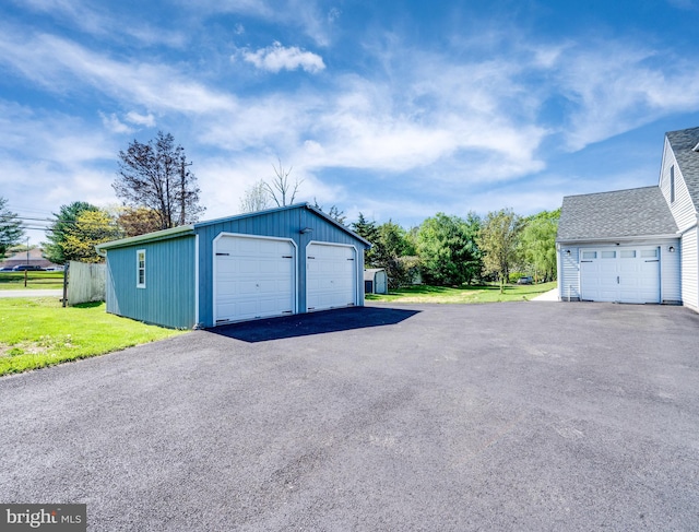 detached garage featuring fence