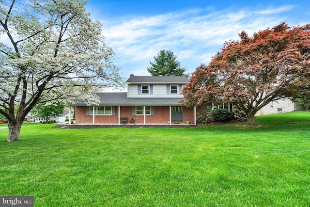 view of front of home with brick siding, a chimney, roof with shingles, and a front lawn