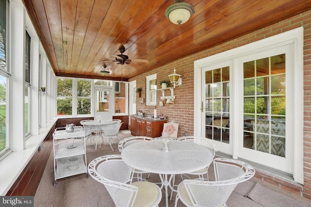 sunroom with a ceiling fan and outdoor dining space