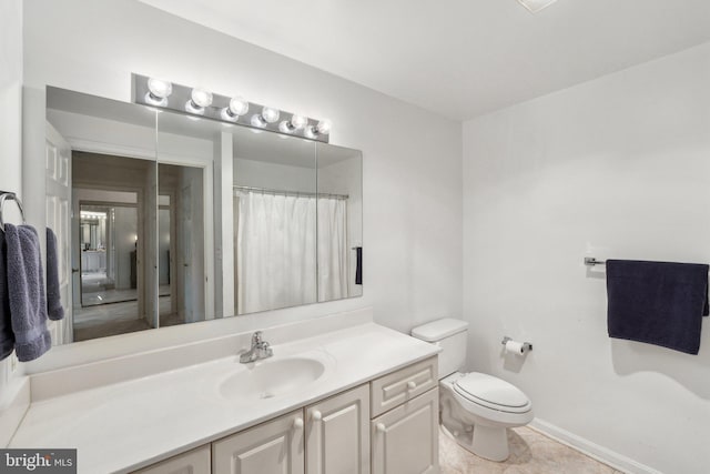 bathroom featuring vanity, baseboards, tile patterned flooring, and toilet