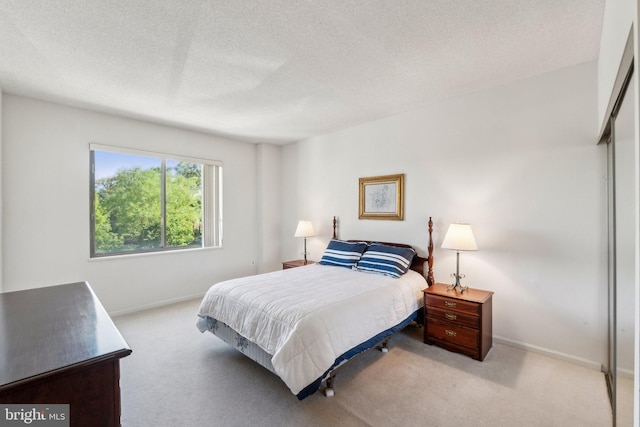 bedroom featuring carpet floors, a textured ceiling, and baseboards