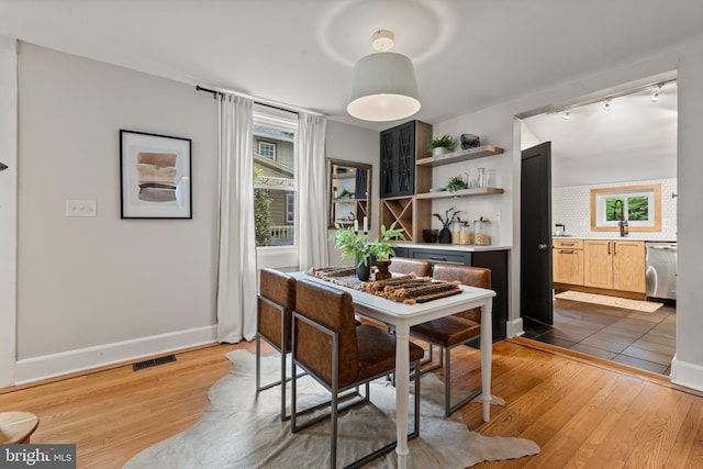 dining area featuring wood finished floors and rail lighting
