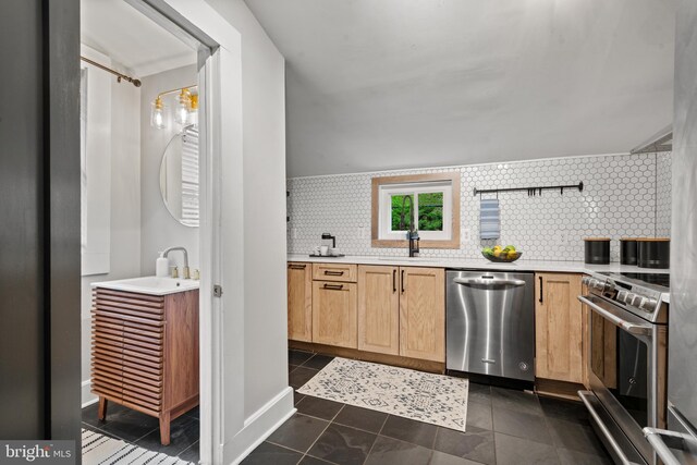 kitchen with stainless steel appliances, tasteful backsplash, light brown cabinets, and a sink