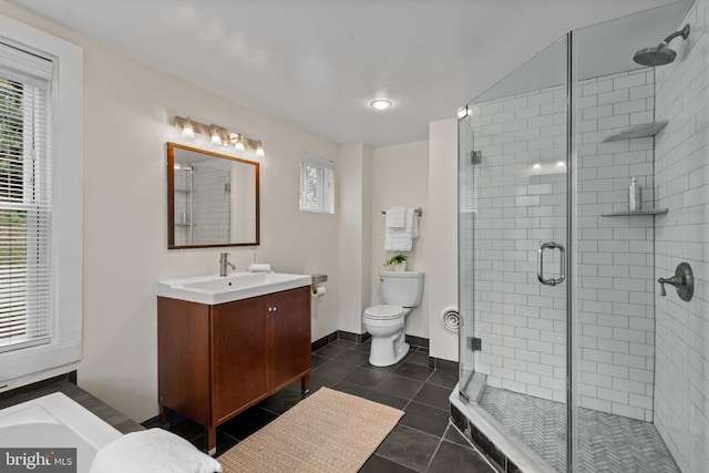full bathroom with a stall shower, toilet, tile patterned flooring, vanity, and baseboards